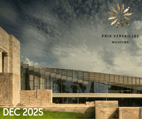 Modern museum building with large glass windows and stone accents under a dramatic sky. "PRIX VERSAILLES MUSEUMS" and a gold emblem appear in the upper right. "DEC 2025" is written in white in the bottom left corner.