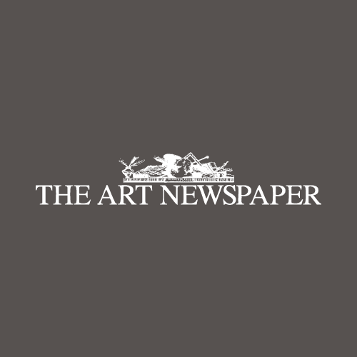 Logo of "The Art Newspaper" featuring the publication's name in white capital letters on a dark grey background. Above the text is a stylized design of various art instruments.
