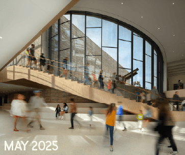 A modern, spacious lobby with large curved windows, a wooden staircase, and blurred people walking. Text in the corner reads "MAY 2025.