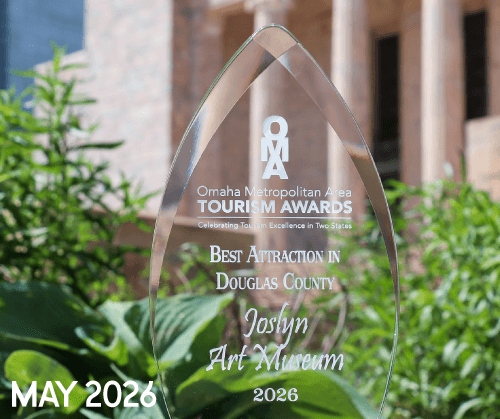 A clear glass award reads "Omaha Metropolitan Area Tourism Awards: Best Attraction in Douglas County, Joslyn Art Museum, 2026," with plants and a building in the background. "MAY 2026" is written in the lower left corner.