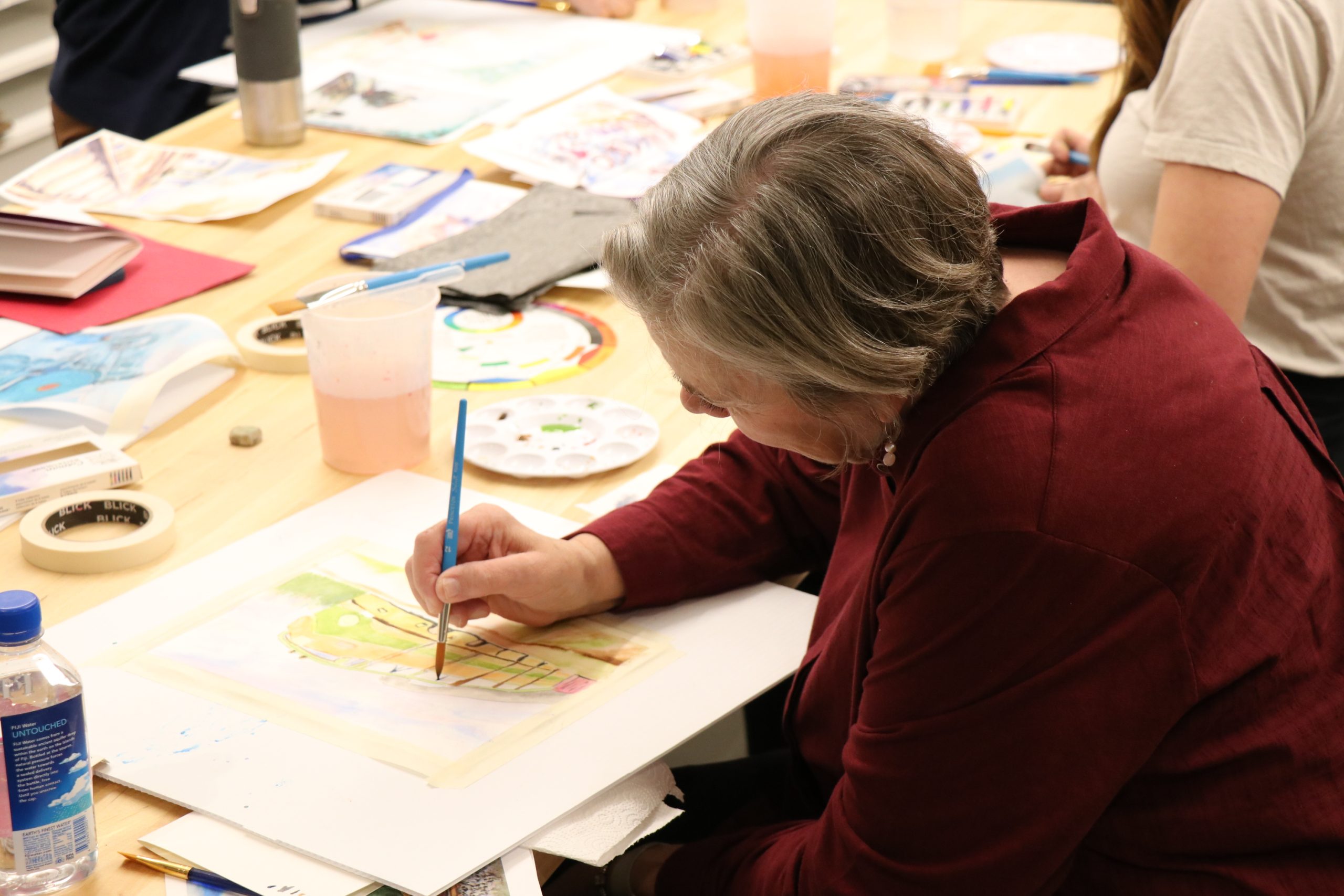 A woman painting on paper.