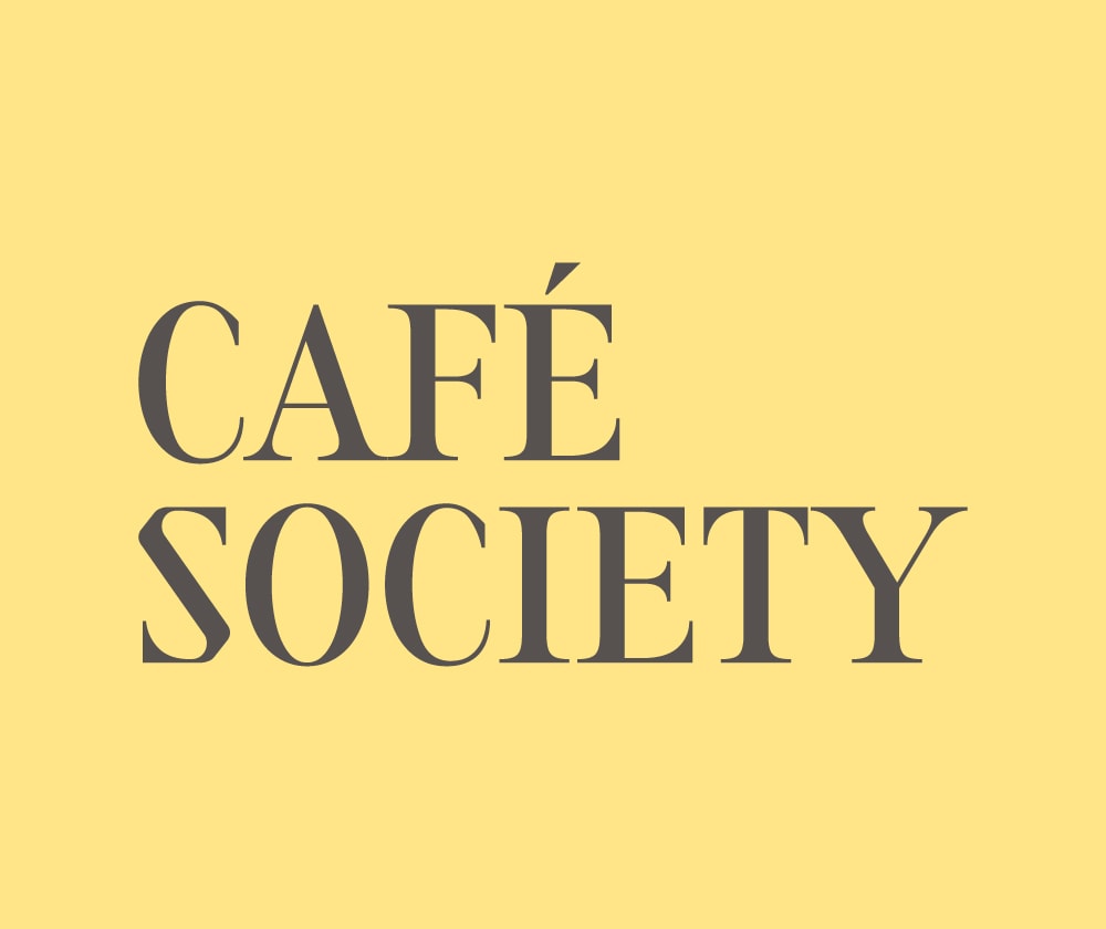 The image displays the words “CAFÉ SOCIETY” in large, bold, serif font on a light yellow background.