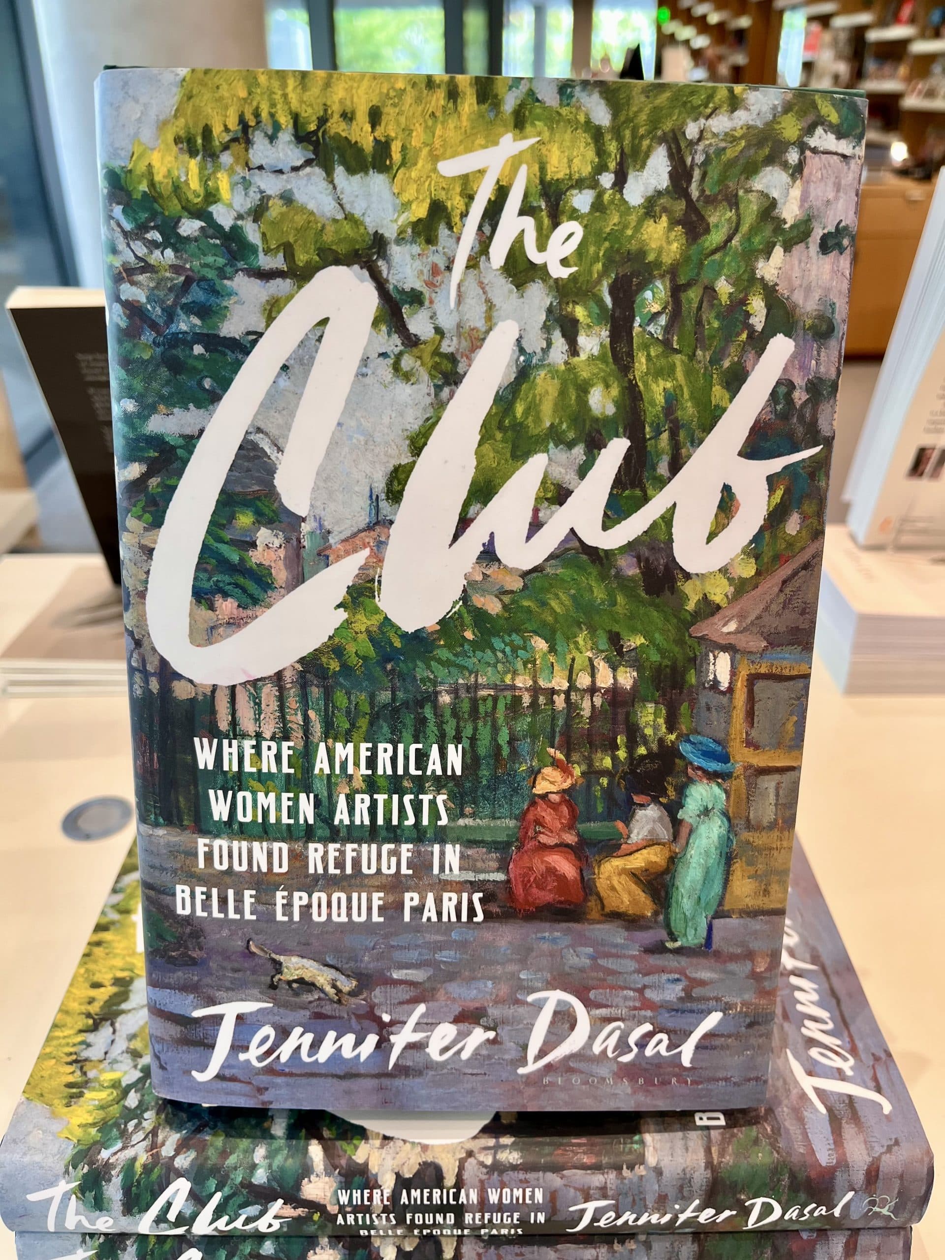 Book cover for “The Club” by Jennifer Dasal, featuring an impressionistic painting of women in a park with trees and a fence. The subtitle reads: “Where American Women Artists Found Refuge in Belle Époque Paris.”.